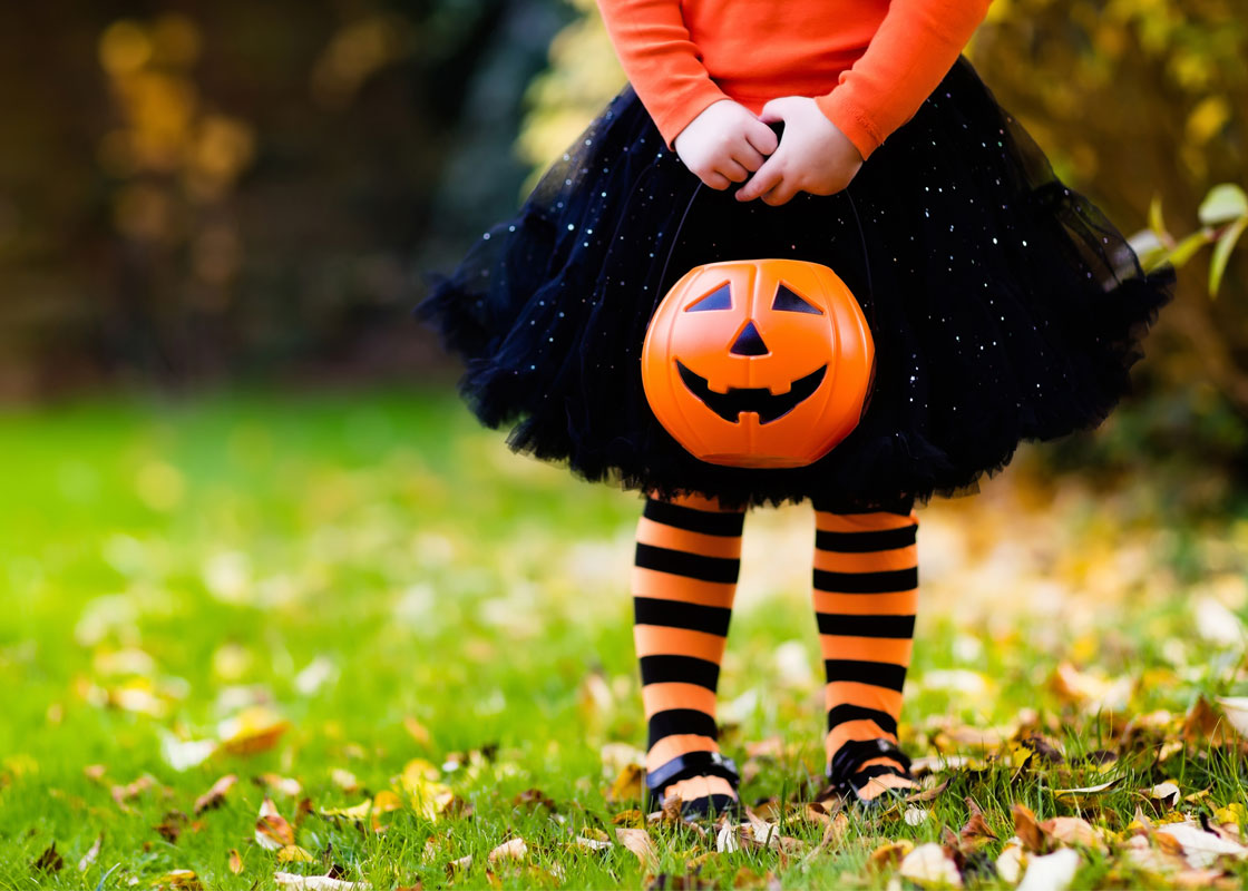 Enfant déguisé avec un sceau pour ramasser des bonbons à l'Halloween